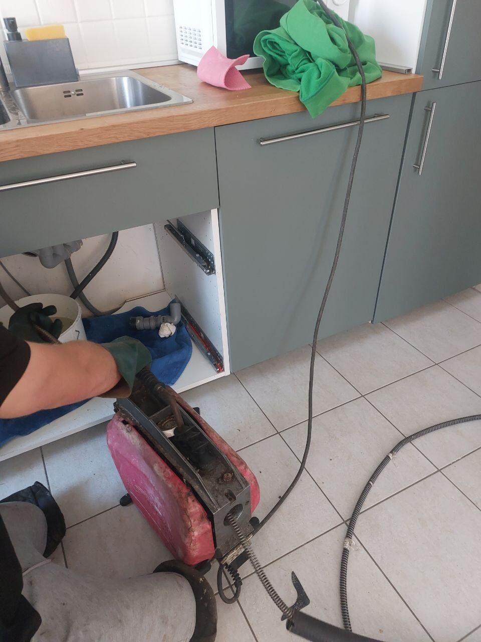 Gépi spirálos készülék a konyhai mosogató alatti szekrény előtt