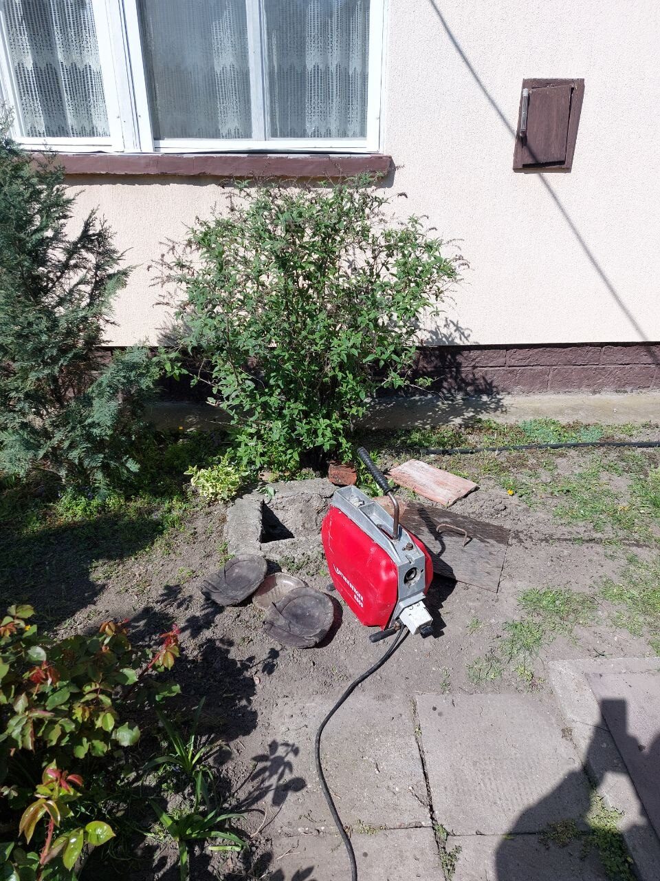 Ugyanaz a kerti akna másik szögből, a gép a járdán